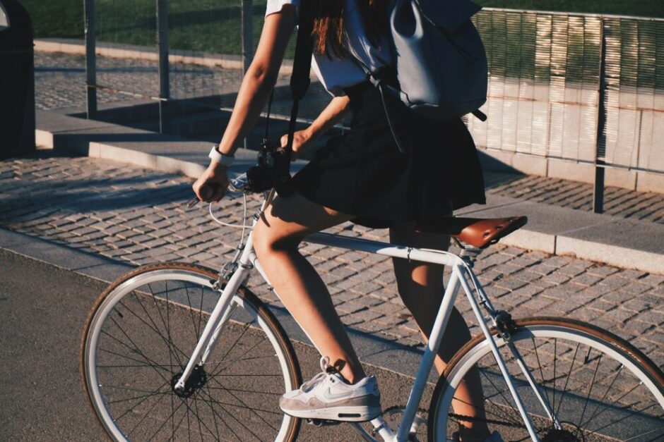 スカイブルーのロードバイクにまたがる若い女性